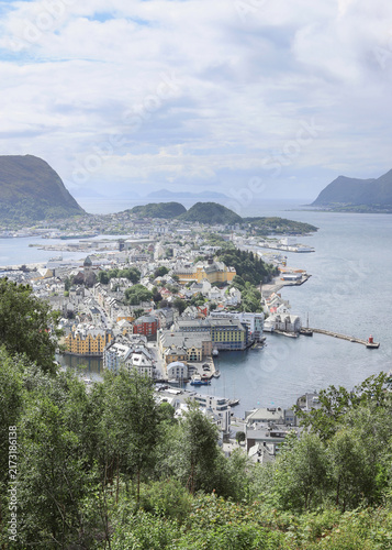 Aerial panoramic view of Alesund town from Aksla hill in Norway. Spectacular landscape of a Norwegian coastal city under dramatic cloudy sky.