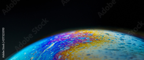 Foto Iridescent soap bubble surface showing fluid abstract colors