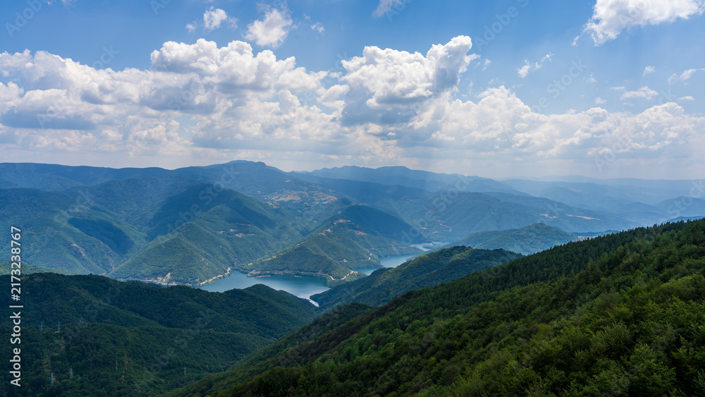 Fototapeta premium Forest mountains and lake under summer clouds