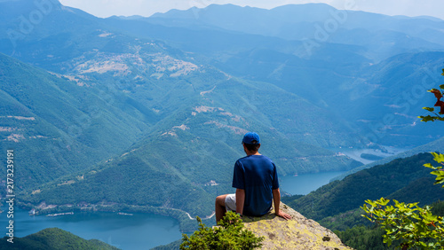 Hiker overlooking a mountain lake valley