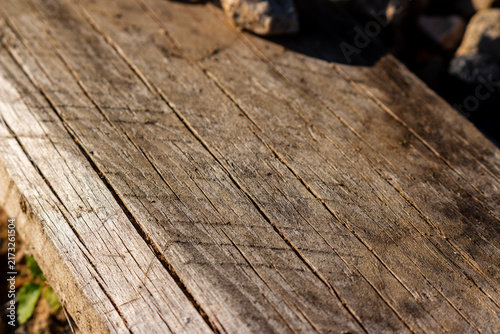 Bild auf Leinwand Weathered wooden board with deep rustic grain and textured cracks, bathed in war