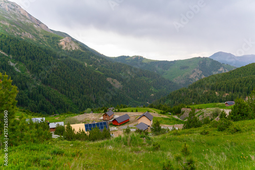 View of small wooden cabins nestled in the lush green mountains of the Accursed Mountains range near Decan, Kosovo.