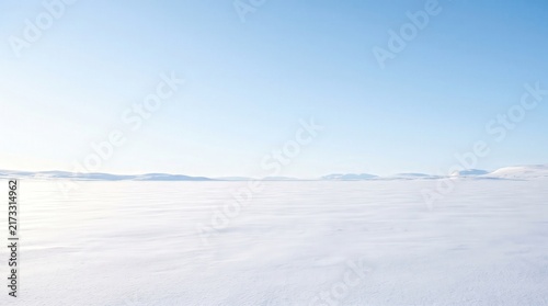 Vast, Tranquil Winter Landscape Under Clear Blue Sky with Snow-Covered Terrain in the Distance