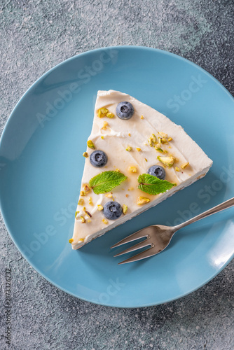 Creamy Mascarpone Cheesecake Slice Served With Blueberries Pistachios Maple Syrup And Mint Leaves