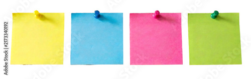 Four colorful sticky notes with pushpins on checkered background.