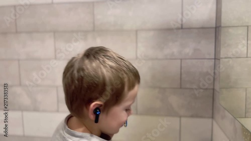 Child brushing teeth in bathroom close-up