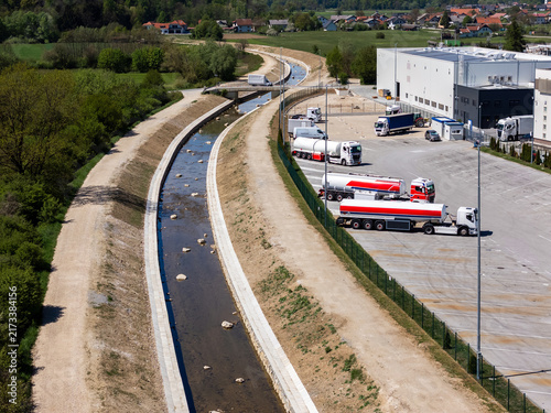Fotografie River restoration work is visible with channel cleaning and widening near a warehouse