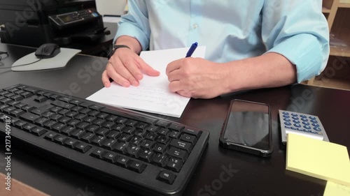 Businessman writing important notes at his office desk