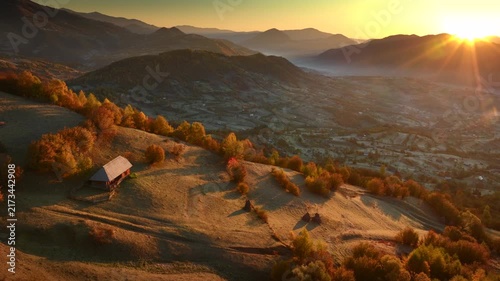 Autumn morning, sunrise over traditional house in Romania, smoke coming out of chimney