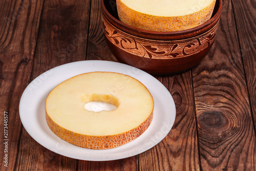 Big annular slice of melon on plate against rest melon