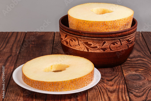 Big annular slice of melon on plate against rest melon