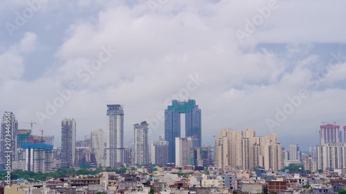 Time lapse gurgaon cityscape with modern skyscrapers, high-rise construction, dense buildings, with heavy monsoon clouds moving overhead showing heavy rainfall over the city