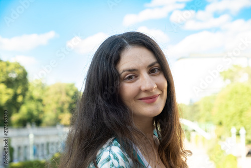 Foto Happy adult female looking at camera with long hair outdoors