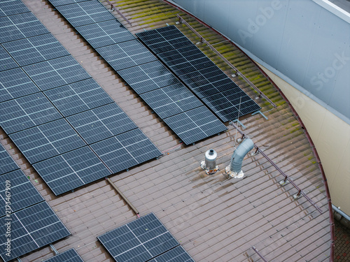 Aerial view of solar panels installed on a wet, overcast rooftop in Riga, Latvia.