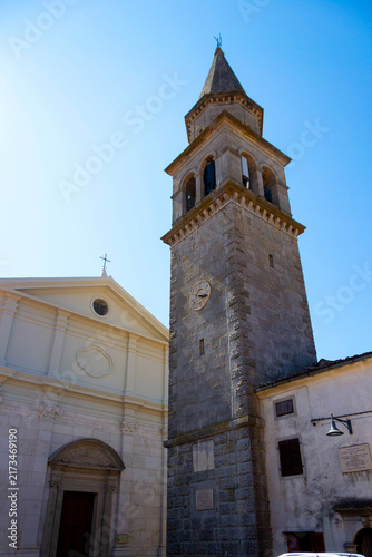 Bild auf Leinwand Historic Stone Bell Tower and Church Facade in Old Town