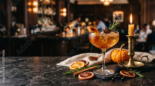 Elegant craft cocktail garnished with rosemary and star anise served on marble surface inside dimly lit moody luxury hotel bar