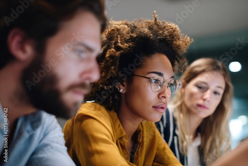Diverse team of professionals collaborating in an office. Focused colleagues working together on a project. Business teamwork and problem-solving concept