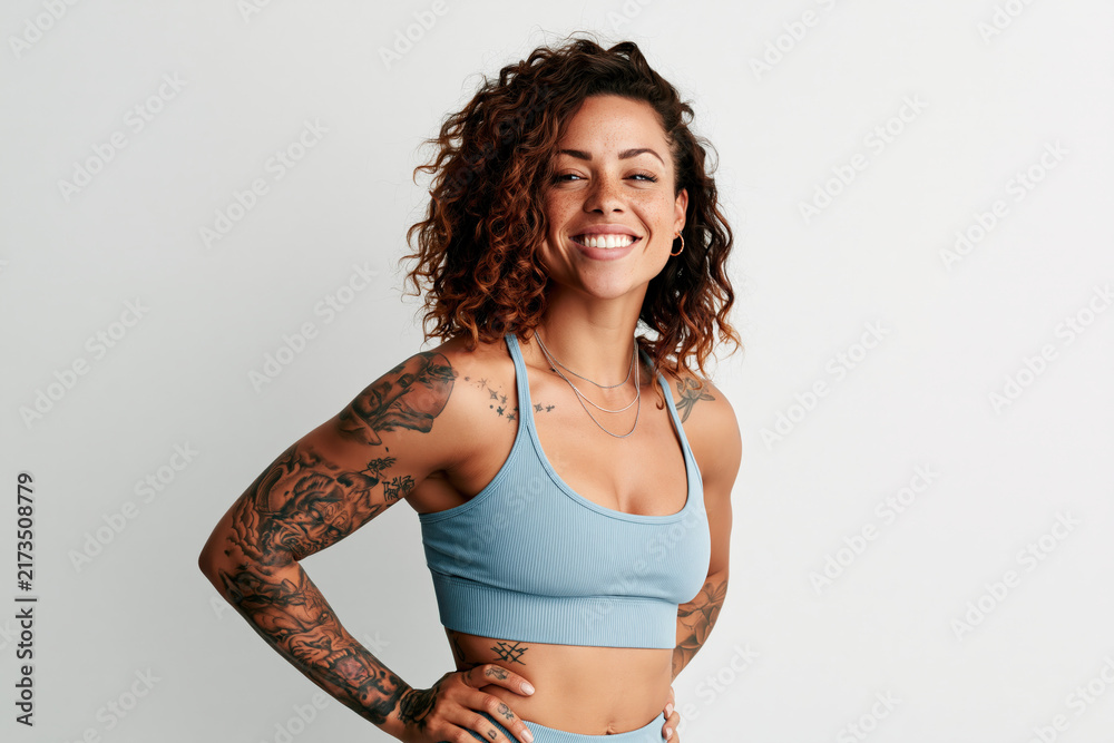 Obraz premium Athletic woman with visible tattoos in sportswear confident