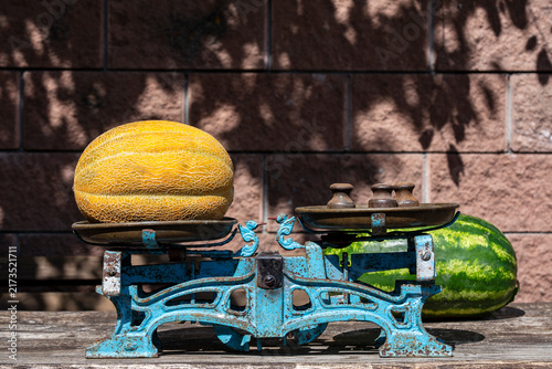 Fotografía Vintage mechanical scale weighing ripe yellow melon outdoors, closeup