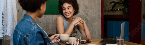 Canvastavla Two beautiful young African American women enjoy a heartfelt conversation while sipping coffee
