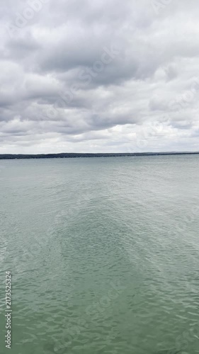 overcast day with layered gray cloud cover reflecting on the rippled lake water surface