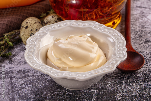 Bild auf Leinwand Creamy mayonnaise in decorative white bowl with quail eggs and wooden spoon on t