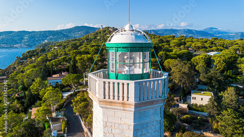 Aerial drone view of the Phare du Cap Ferrat lighthouse surrounded by pine forests and the Mediterranean Sea in Saint-Jean-Cap-Ferrat, France