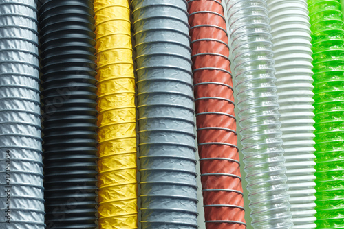 Industrial corrugated pipes of various types and made of different materials stand in row, tech industrial technology background