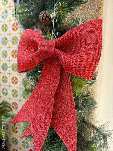 red glittery christmas bow on pine garland, holiday decor, banner, concept of retail, events, home