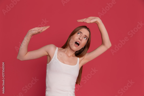Surprised woman measuring a large imaginary object