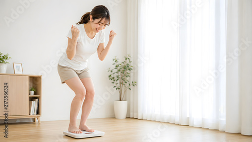 Tapety artystyczne 体重計に乗りダイエットの成果を喜ぶ若い日本人女性