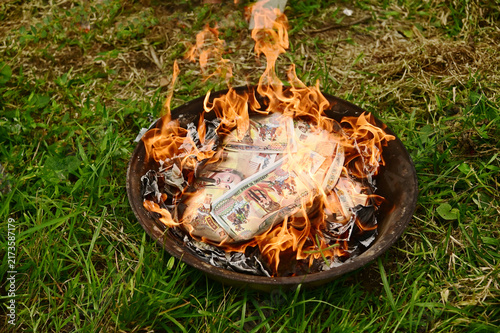 Cuadro en lienzo Ritual of burning joss paper, also known as ghost money, inside a metal container placed on the grass