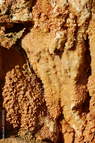 Foto A  close-up, rough geological formation with crystalline mineral deposits, resembling a cave wall or mineral crust