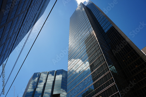 Modern glass skyscrapers reflecting clouds on a clear day