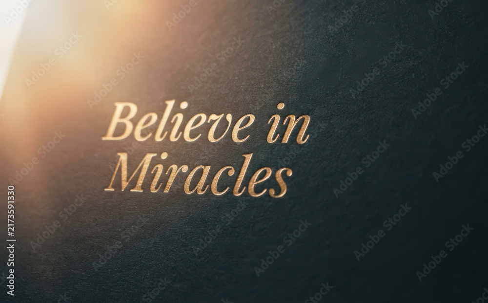 Fototapeta premium Believe in Miracles gold text embossed on dark textured paper inspirational quote for motivation and hope graphic design concepts