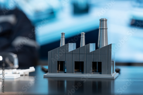 Foto Close-up of a small factory model with smokestacks on a desk, with a blurred office background