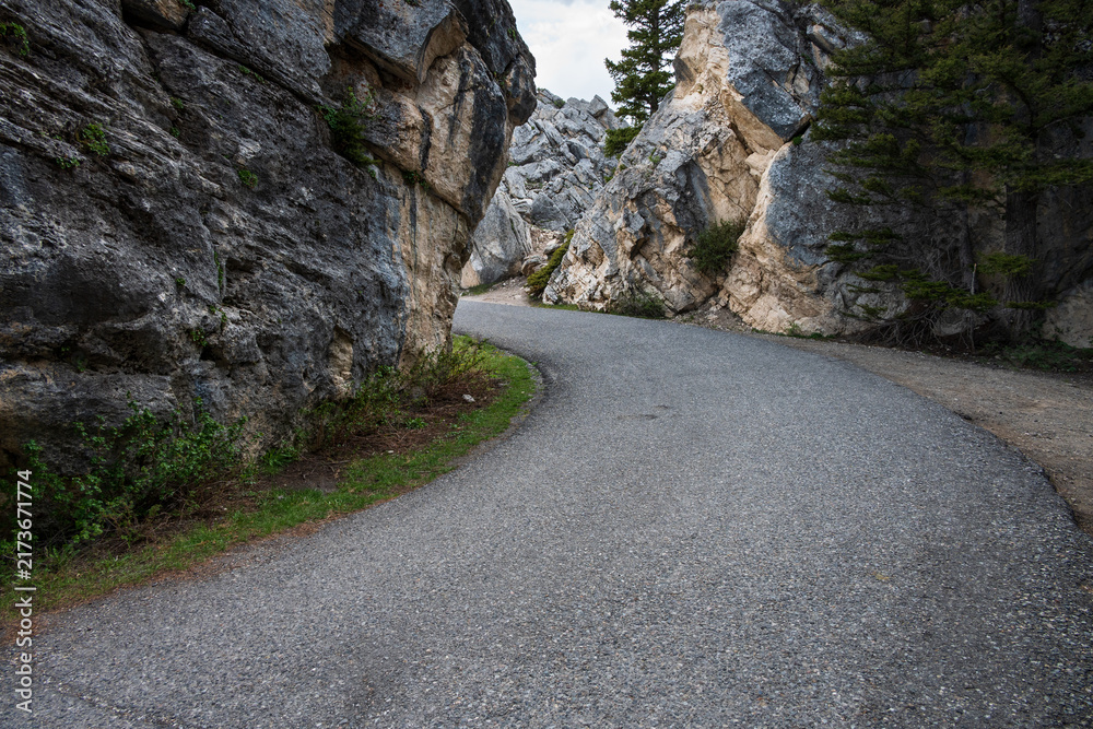Fototapeta premium Side road on the way to Kingman Pass through rock cliff, mystery around the corner, The Golden Gate area, traveling in Yellowstone National Park for summer vacation 