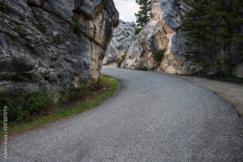 Side road on the way to Kingman Pass through rock cliff, mystery around the corner, The Golden Gate area, traveling in Yellowstone National Park for summer vacation
