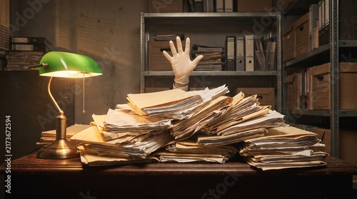 Gloved hand struggling from a colossal pile of documents on a vintage desk, symbolizing administrative overload and unmanageable bureaucracy in a dim office