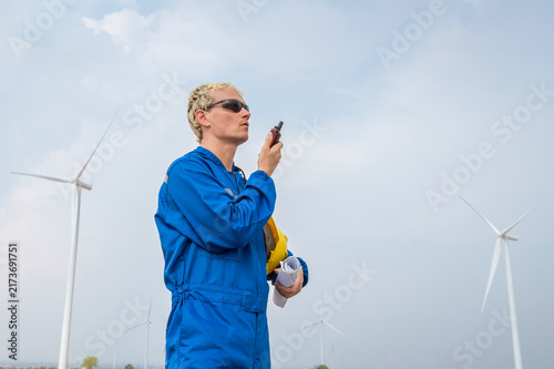 Принти на полотні Male engineer in coverall looking and talking by radio communication working at