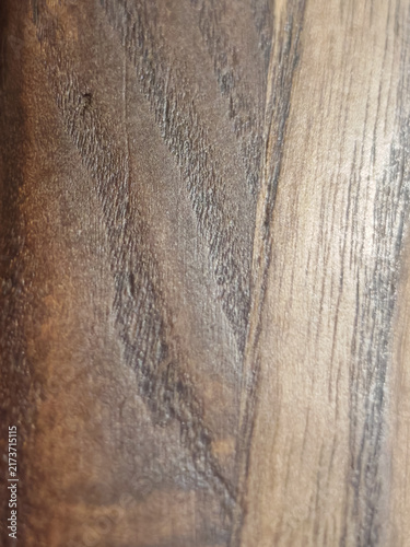High-resolution macro photograph displaying natural dark walnut wood grain texture with rich brown timber fibers and light sapwood contrast. Ideal target for interior design mockups, luxury furniture