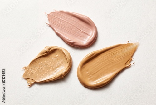 Three Shades of Liquid Foundation Cream Smudges on White Background
