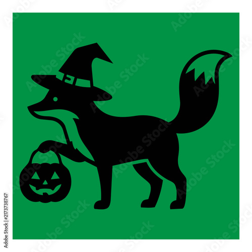 Black silhouette of a cute fox wearing a witch hat and holding a jackolantern pumpkin for trick or treat festivities during the spooky autumn season celebration representing magical fall holiday