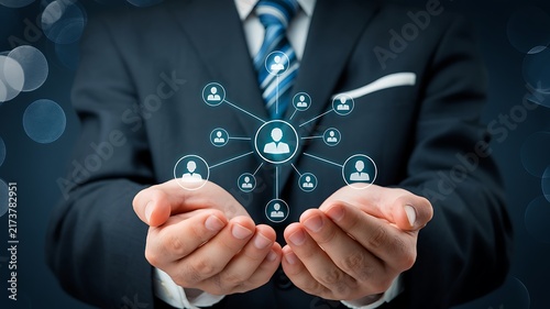 A businessman in a suit holding an abstract network of people in his hands, symbolizing connection and organization
