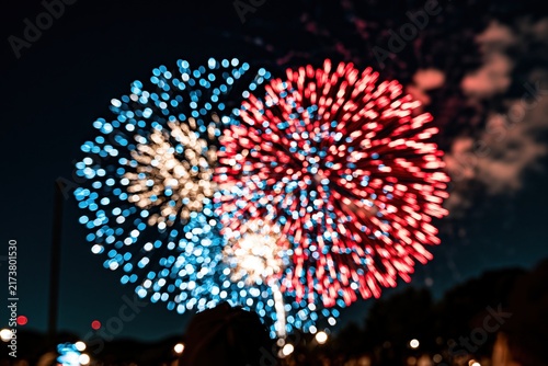 Colorful fireworks explode in night sky above crowd