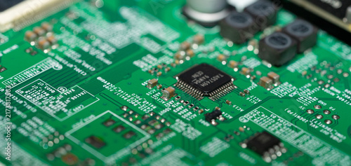 Foto Selective focus microchip on green printed circuit board with shallow depth of f