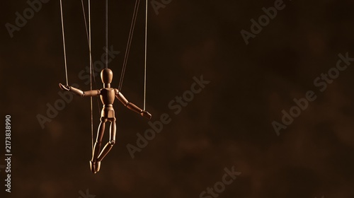 Wooden marionette puppet suspended by strings against dark