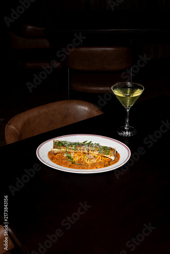 Elegant dinner plate with pasta and wine glass.