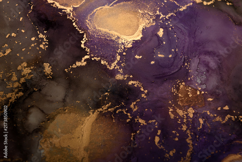 Wide shot of an abstract background featuring purple-brown and gold ink swirls.