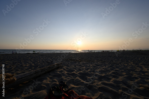 People enjoying sundown at tuscany beach. Togetherness at italian beach. Marina di Torre del LAgo, Tuscany, Italy, Europe.